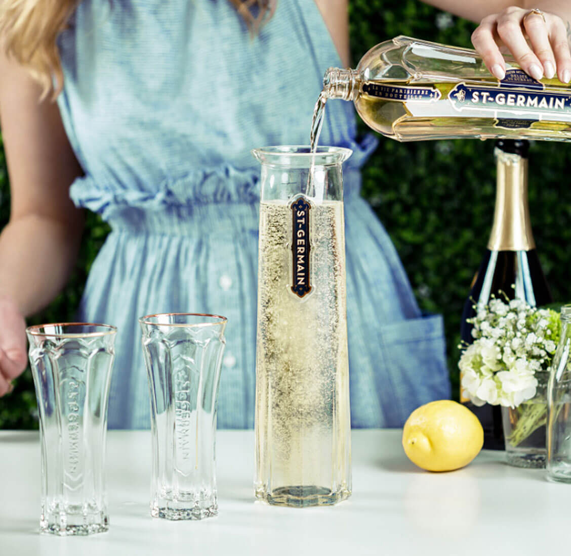 Girl pouring ST~GERMAIN into carafe.